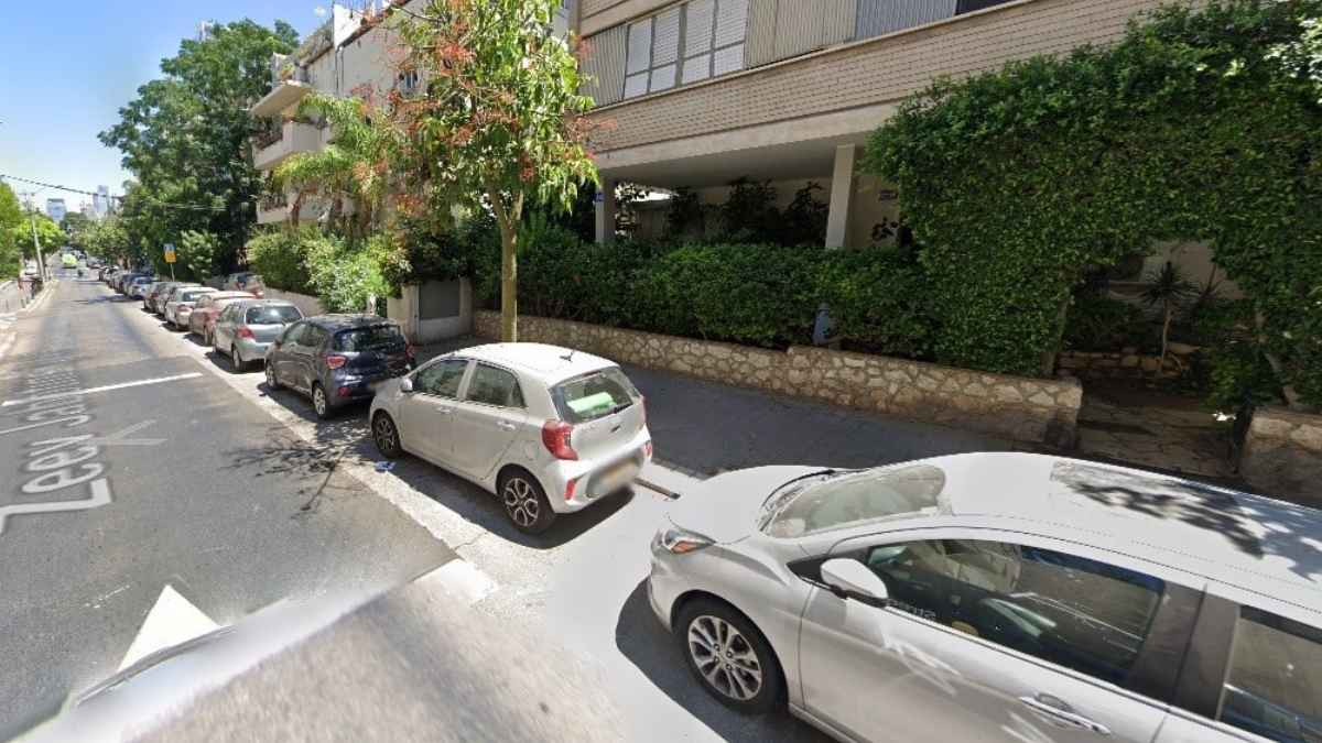 רחוב זאב ז'בוטינסקי בתל אביב עם מקומות חניה מוסדרים בצד הדרך בסמוך למבני מגורים ומשרדים
